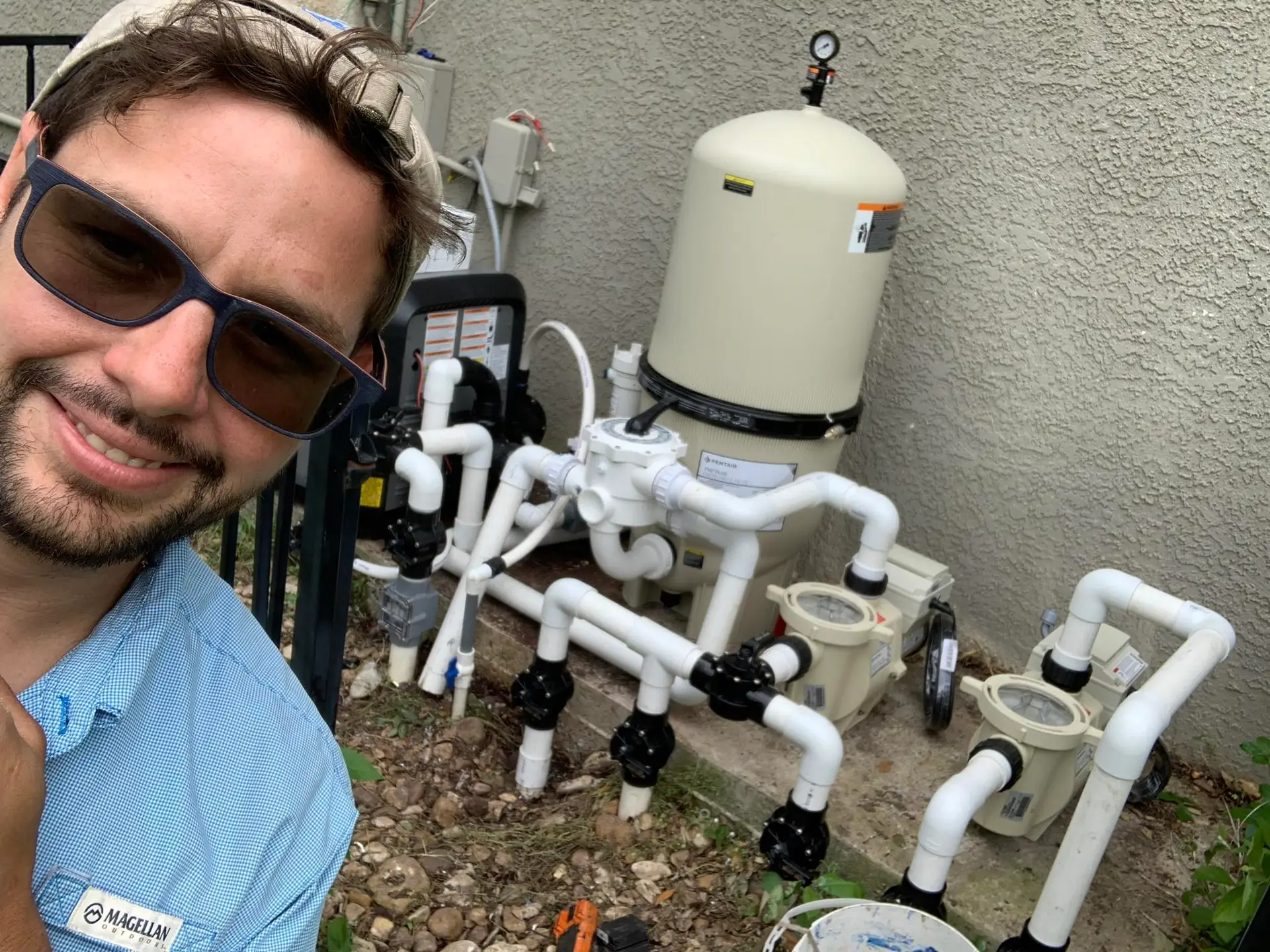 Johnathan, Owner of Bermuda Blue Pool Service taking a selfie with a finished new pool equipment pad.